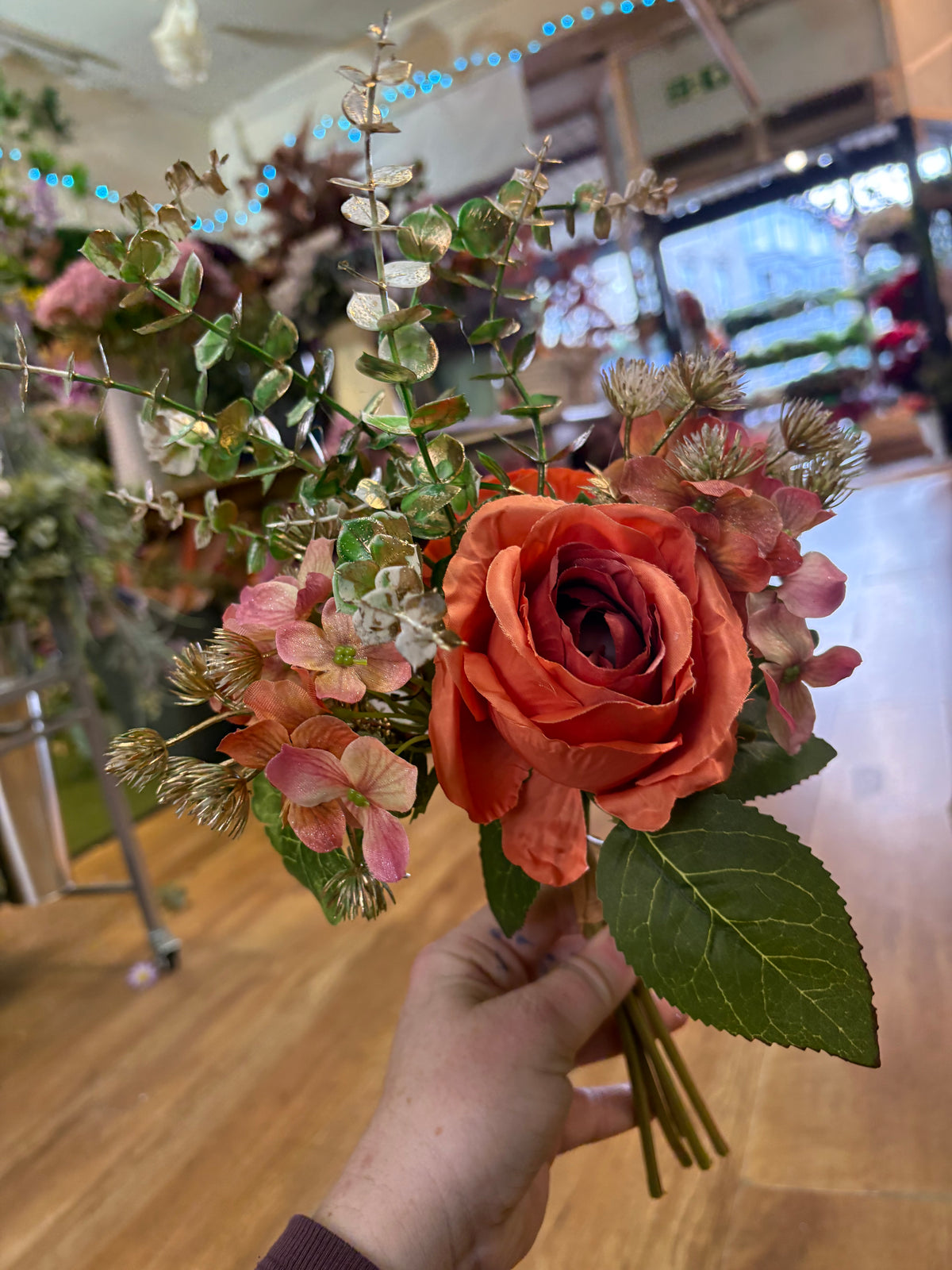 Hand tied bunch of mixed florals and gold shimmered foliage