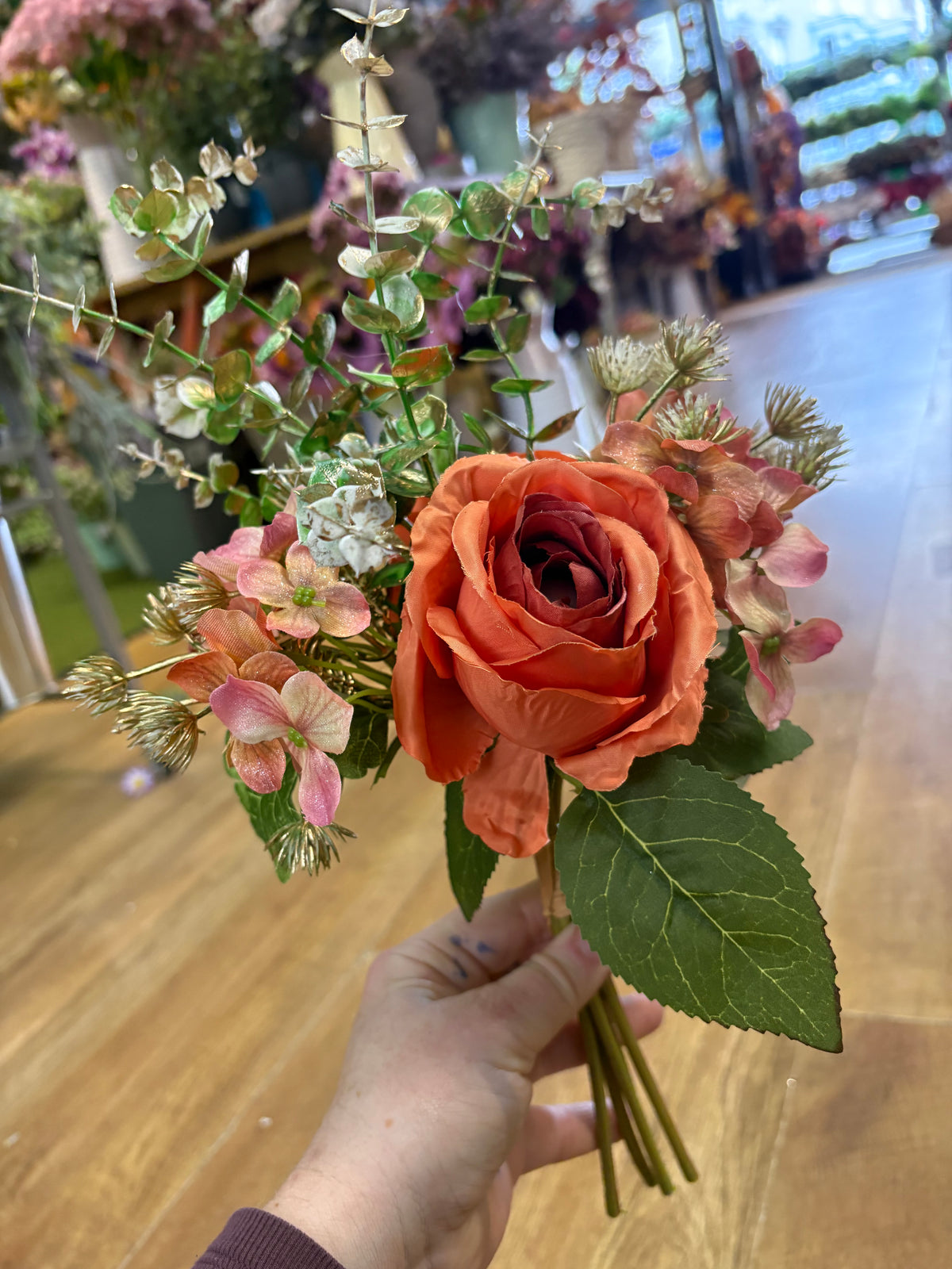 Hand tied bunch of mixed florals and gold shimmered foliage