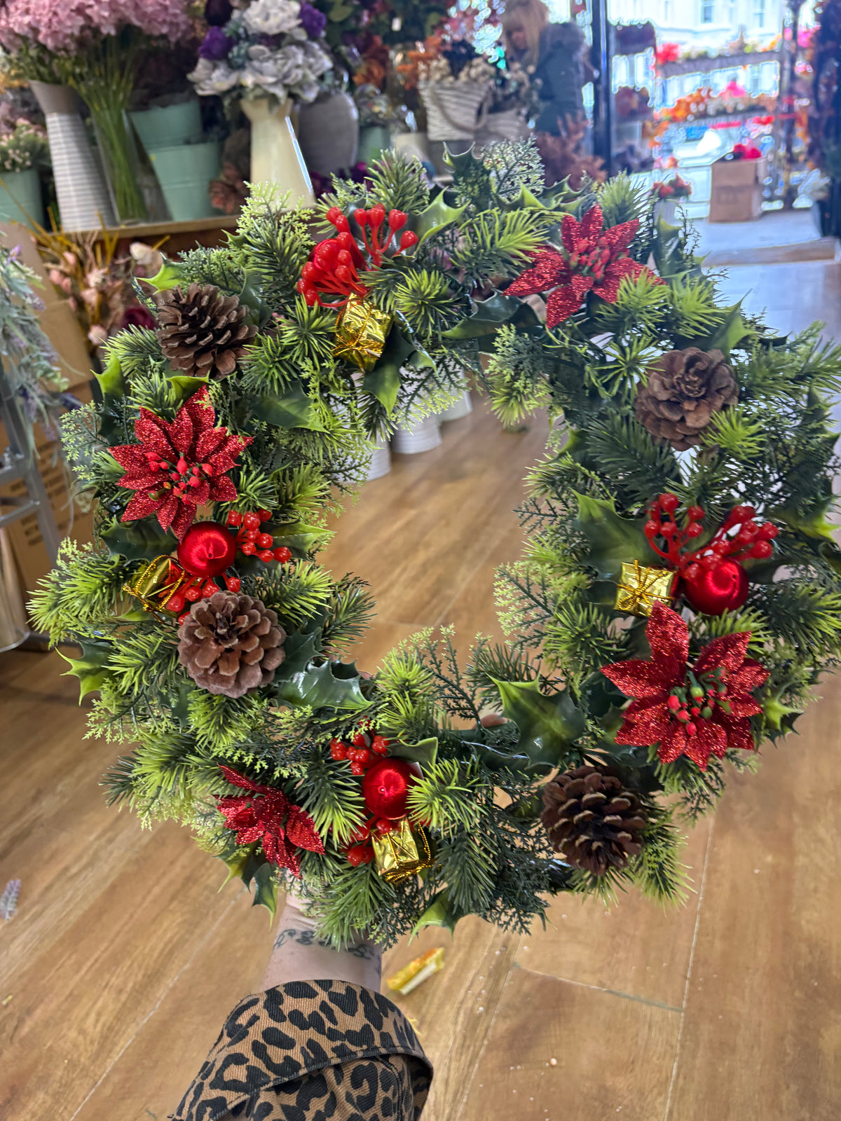 18” wreath with red poinsettias, cones, gifts and glitter balls