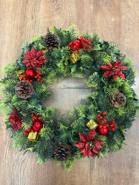 18” wreath with red poinsettias, cones, gifts and glitter balls