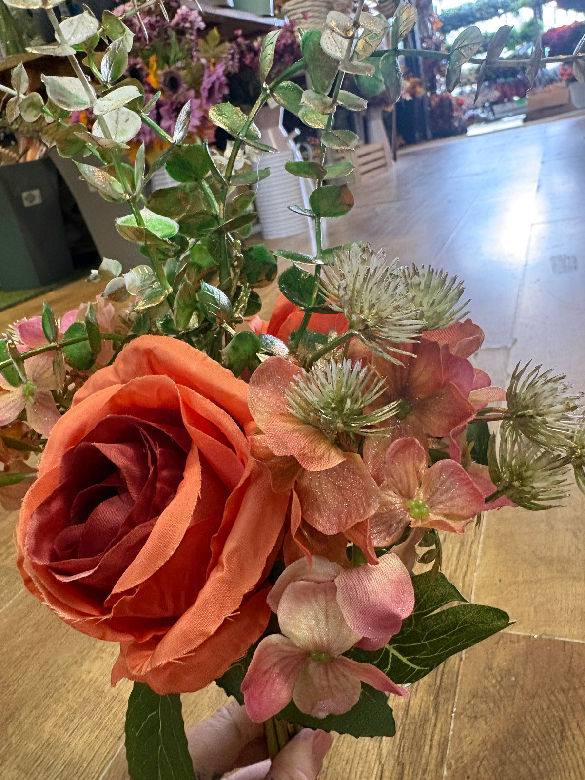 Hand tied bunch of mixed florals and gold shimmered foliage