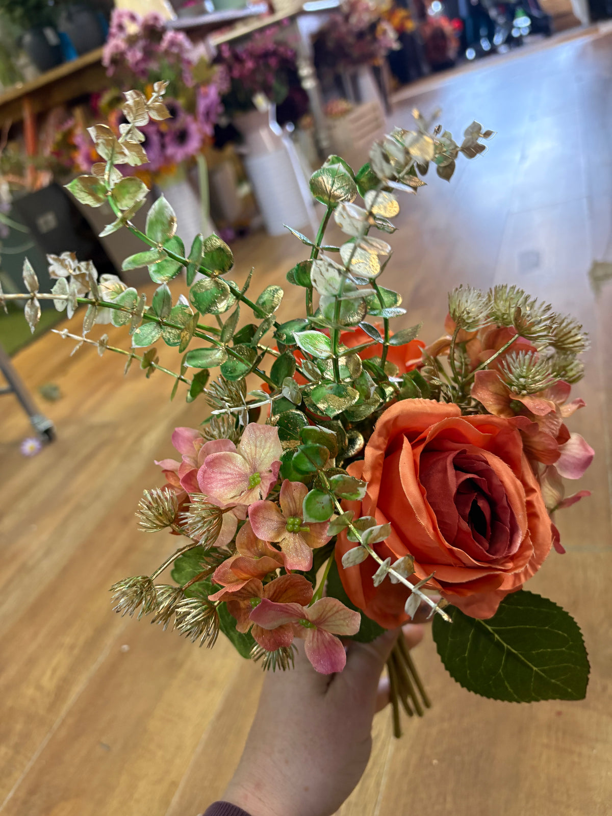 Hand tied bunch of mixed florals and gold shimmered foliage