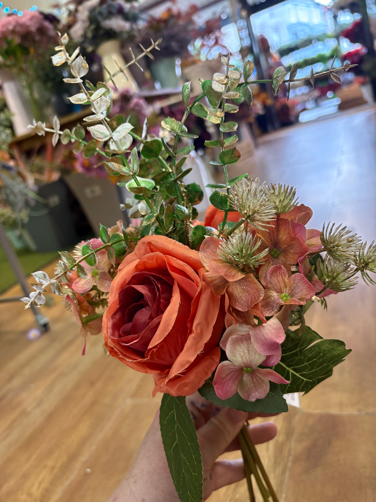 Hand tied bunch of mixed florals and gold shimmered foliage