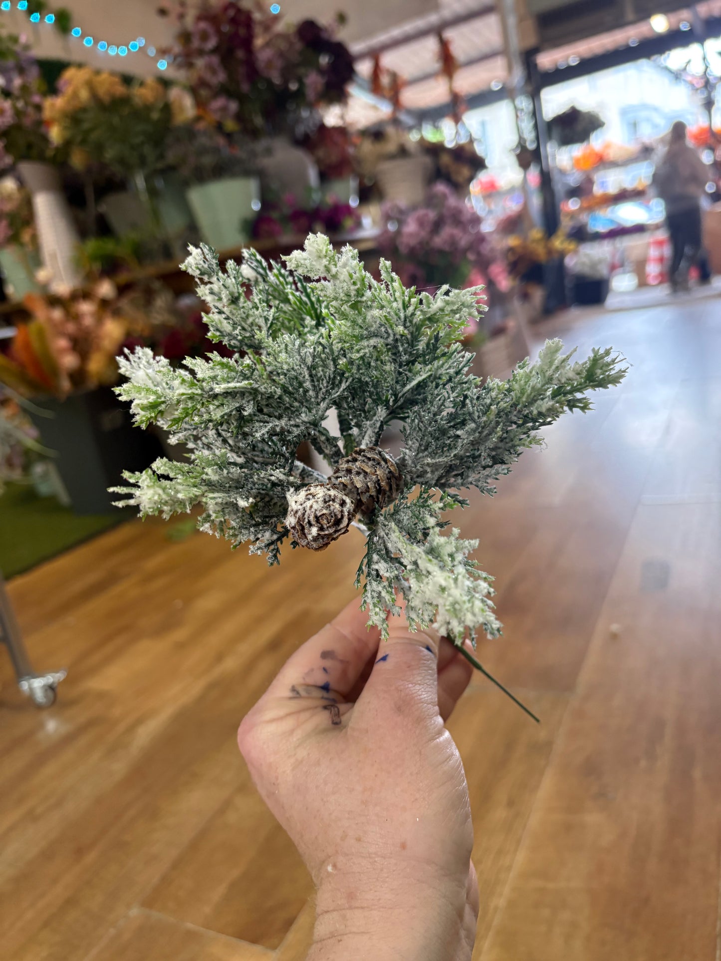 Small frosted foliage pick with miniature cones
