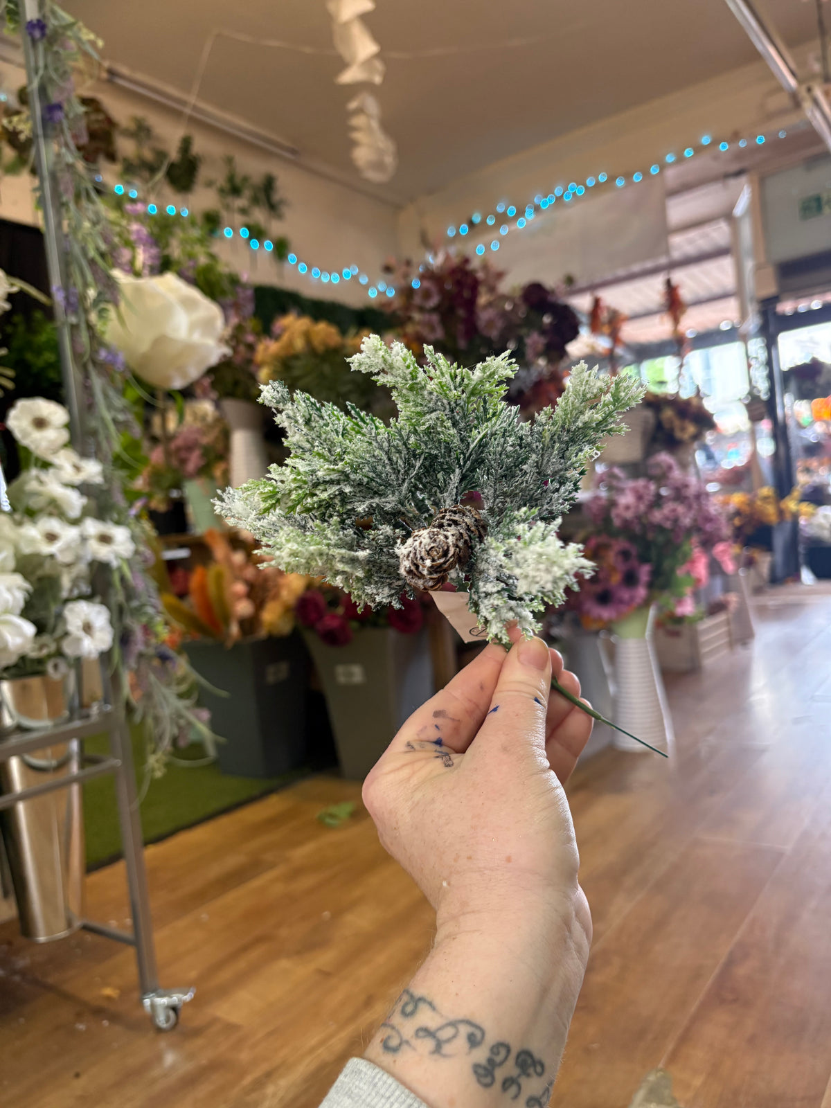 Small frosted foliage pick with miniature cones