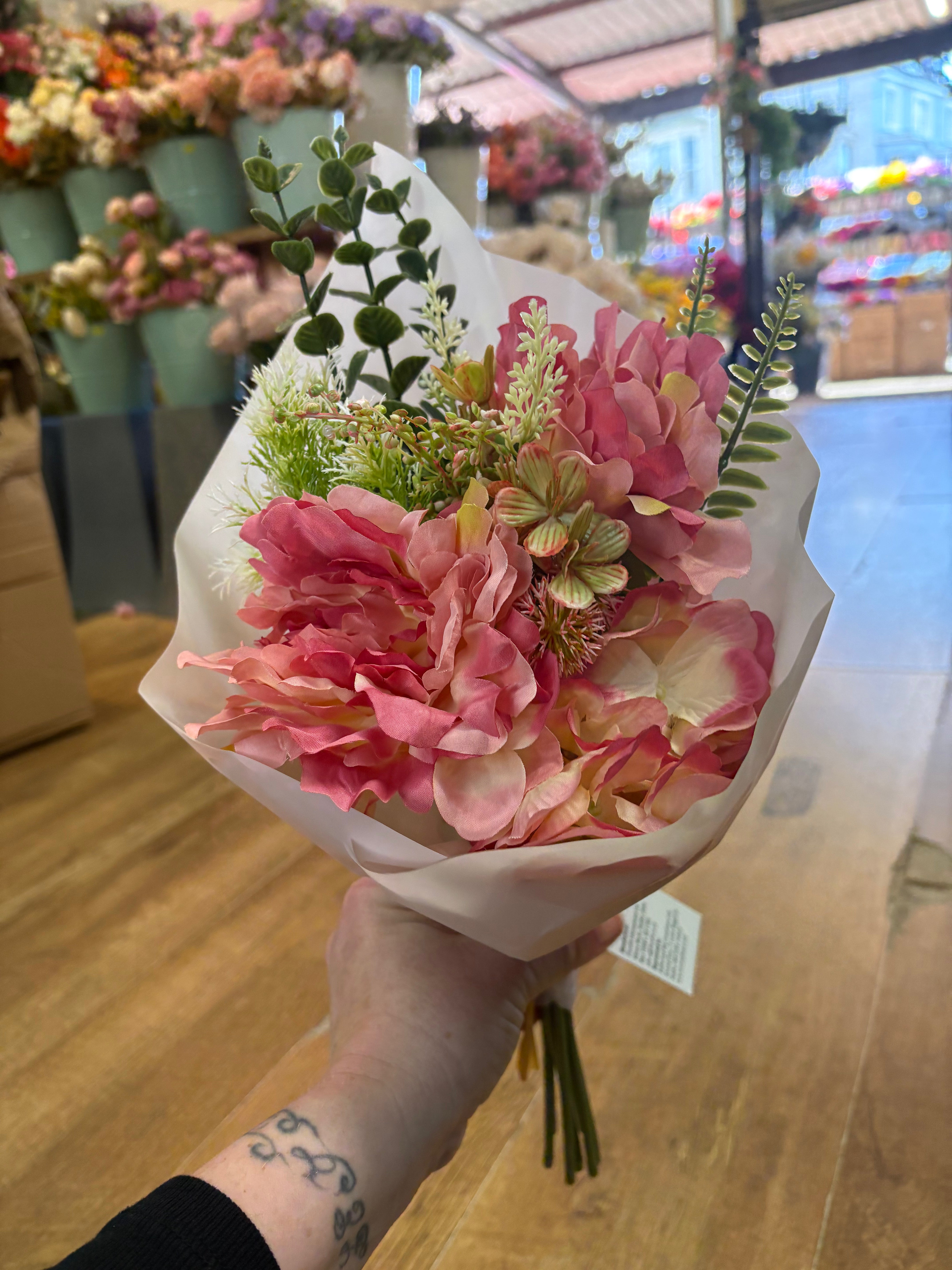 Small wrapped pink peony and mixed foliage bouquet