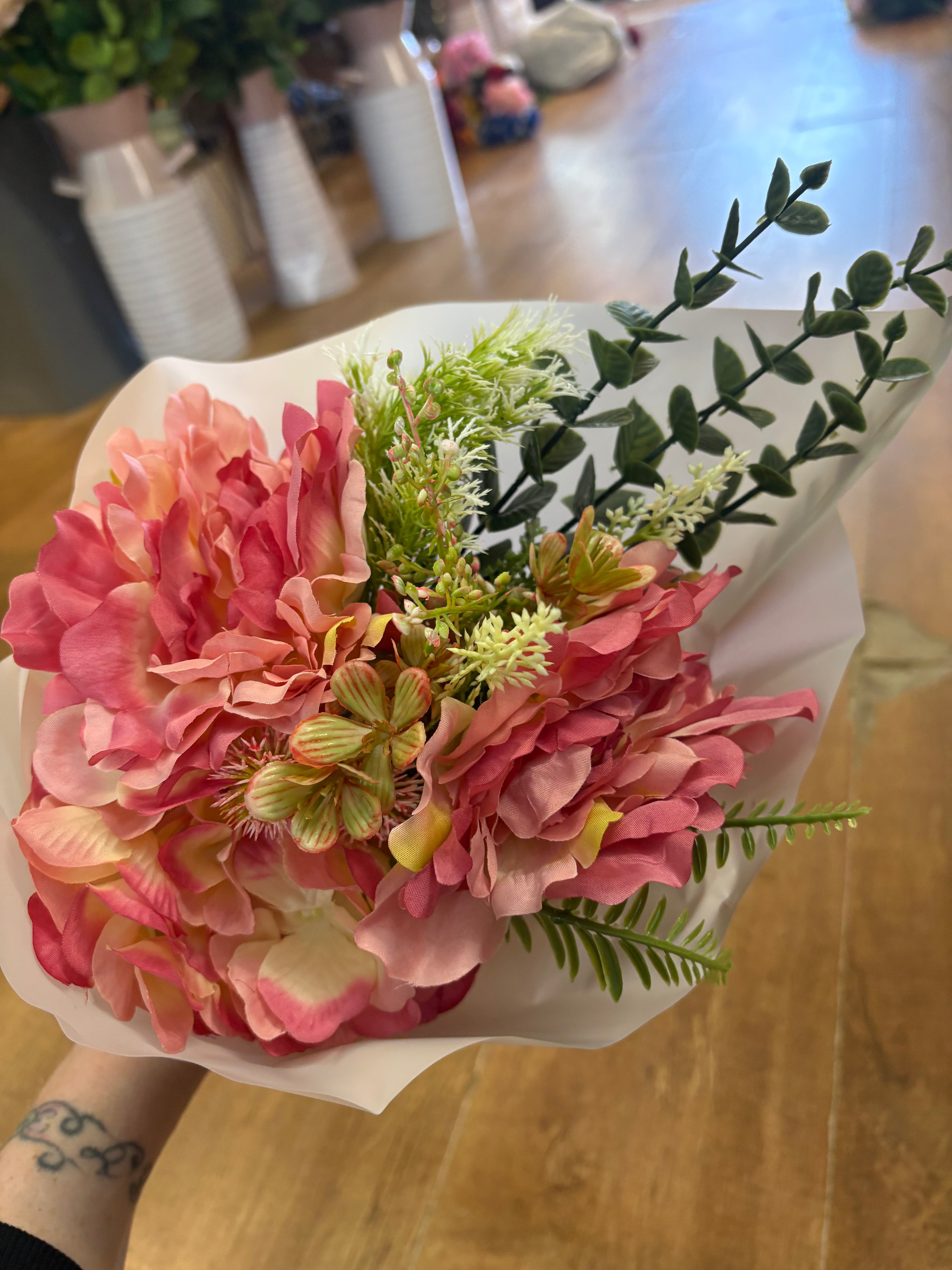 Small wrapped pink peony and mixed foliage bouquet
