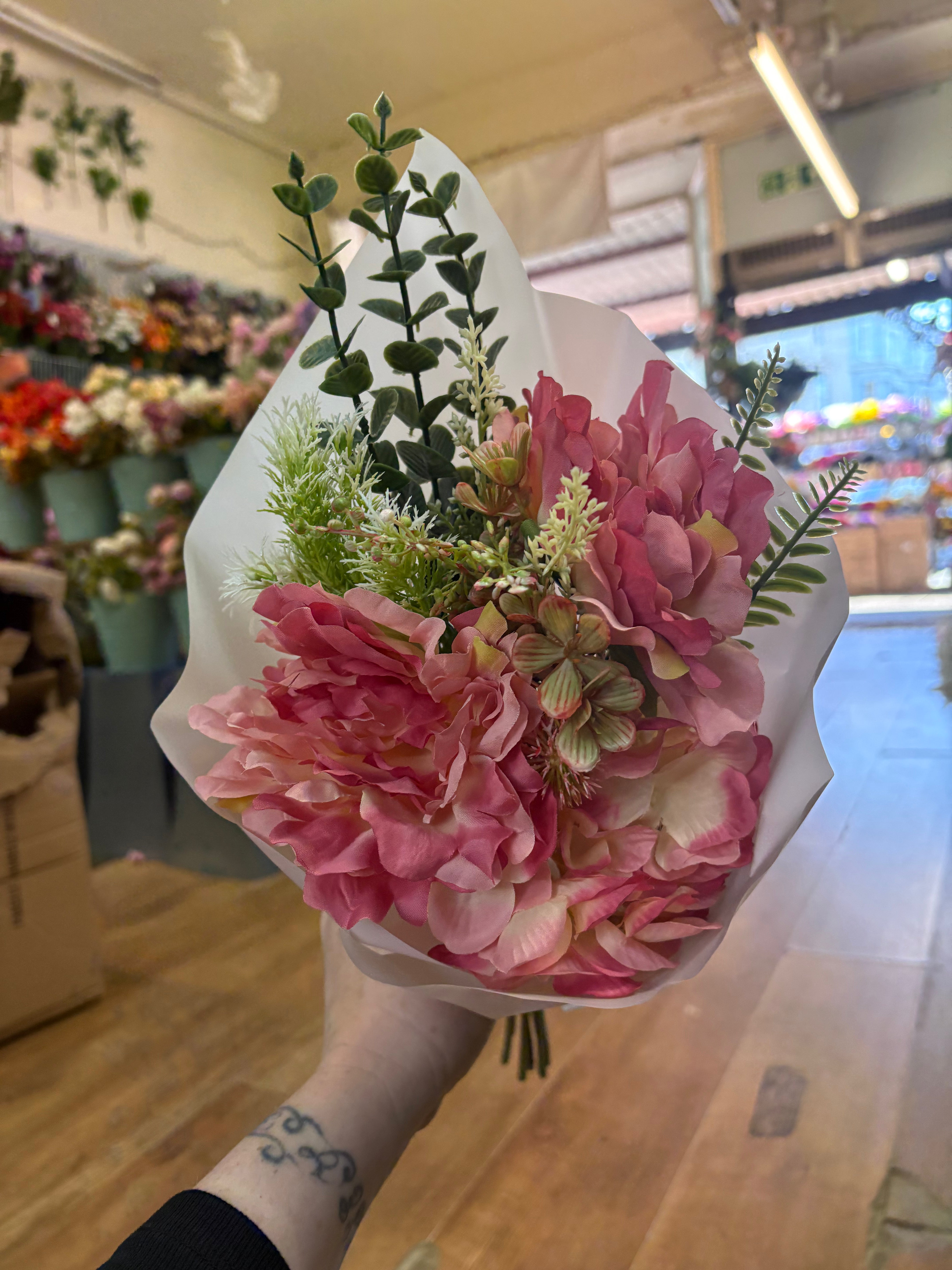 Small wrapped pink peony and mixed foliage bouquet