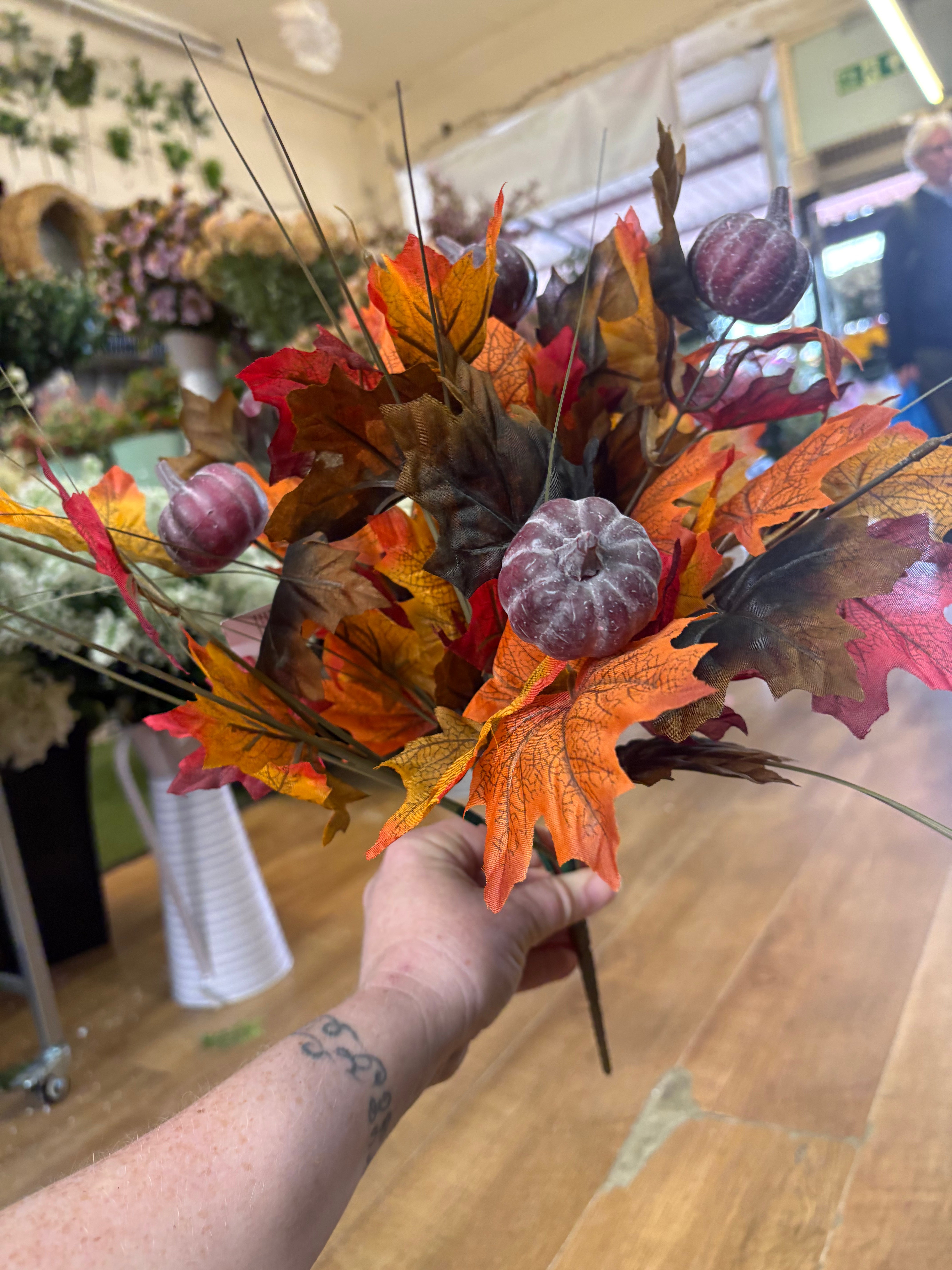 Large autumn leaves and dark pumpkins bunch