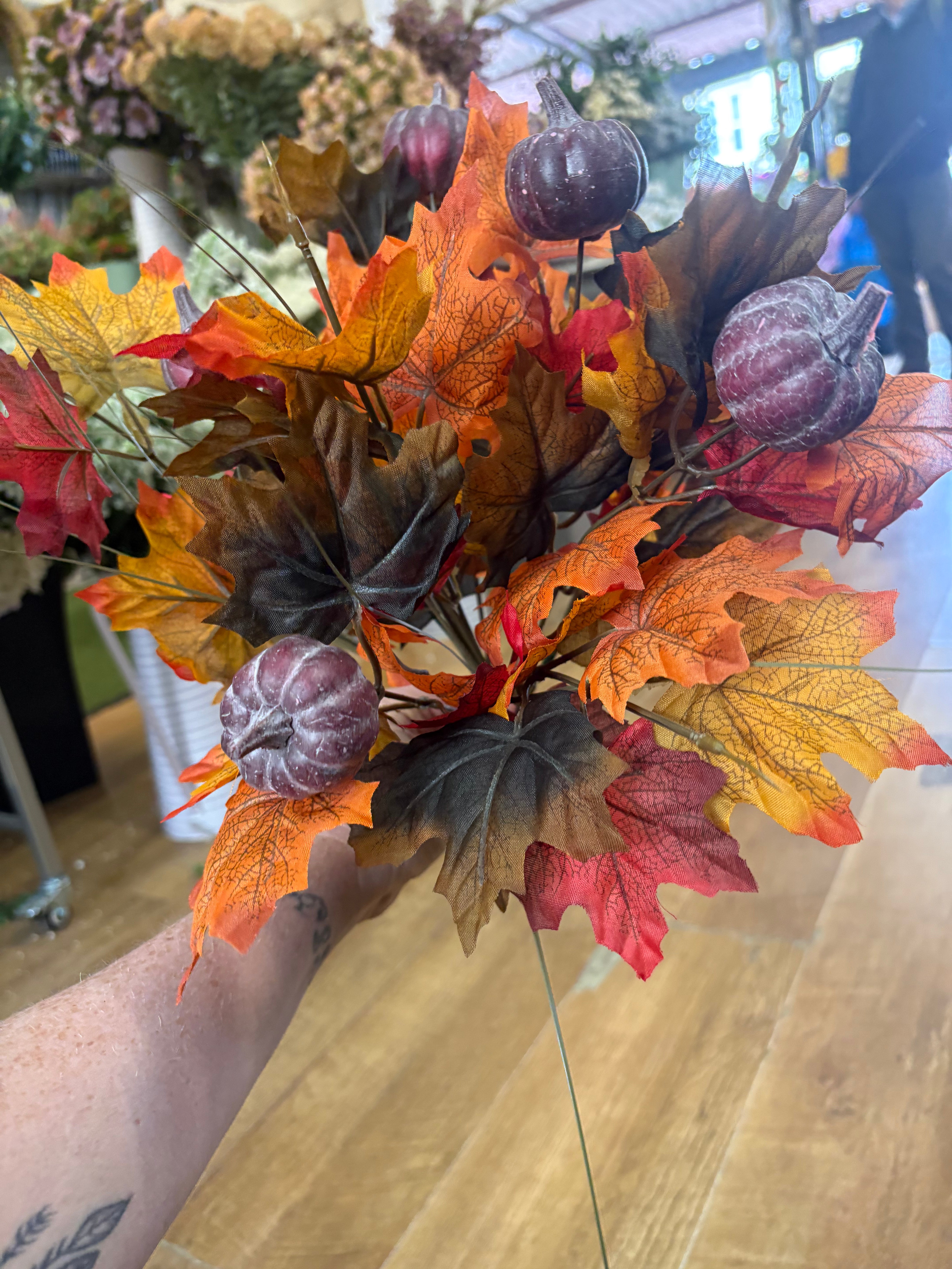 Large autumn leaves and dark pumpkins bunch