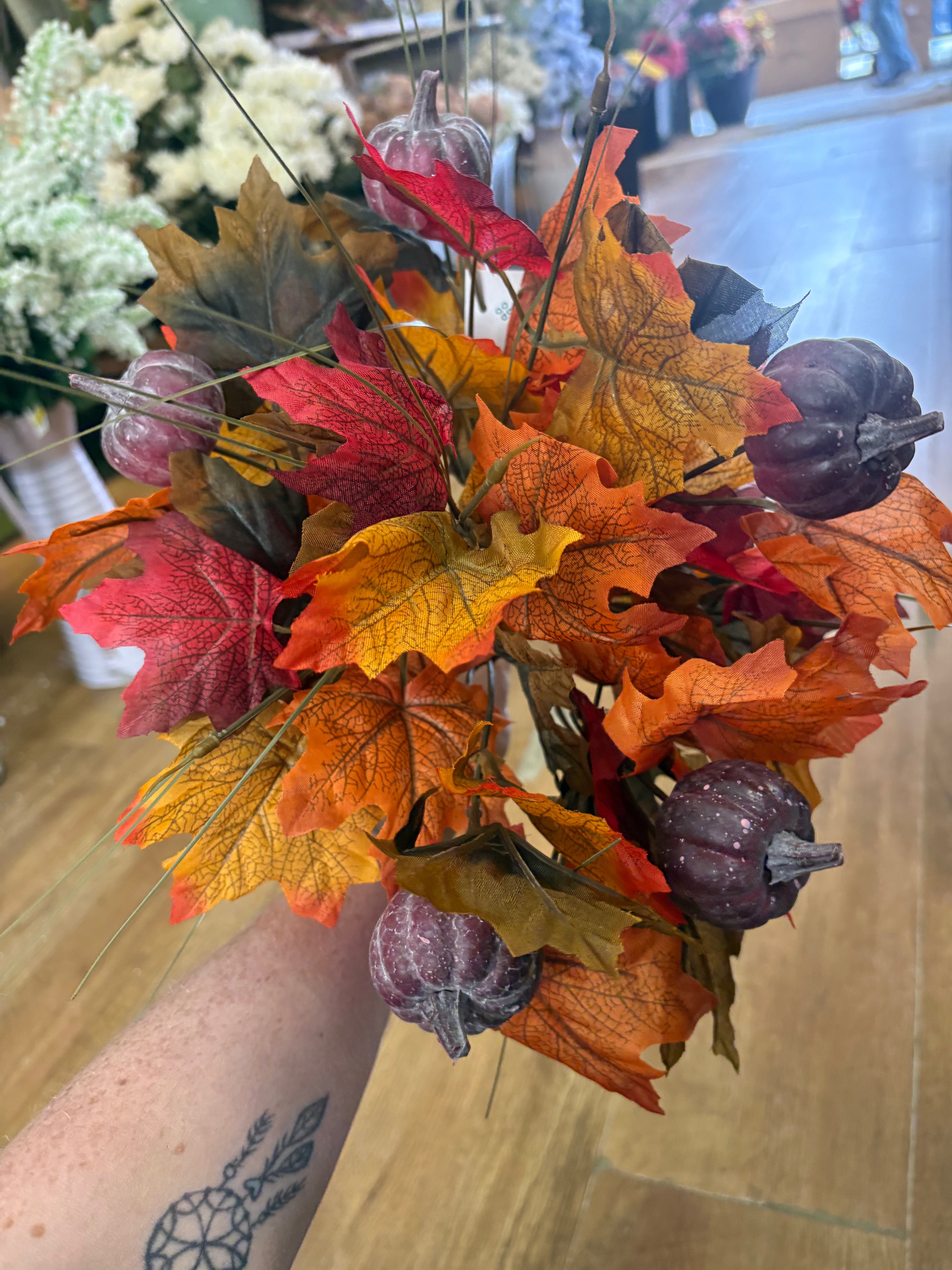 Large autumn leaves and dark pumpkins bunch