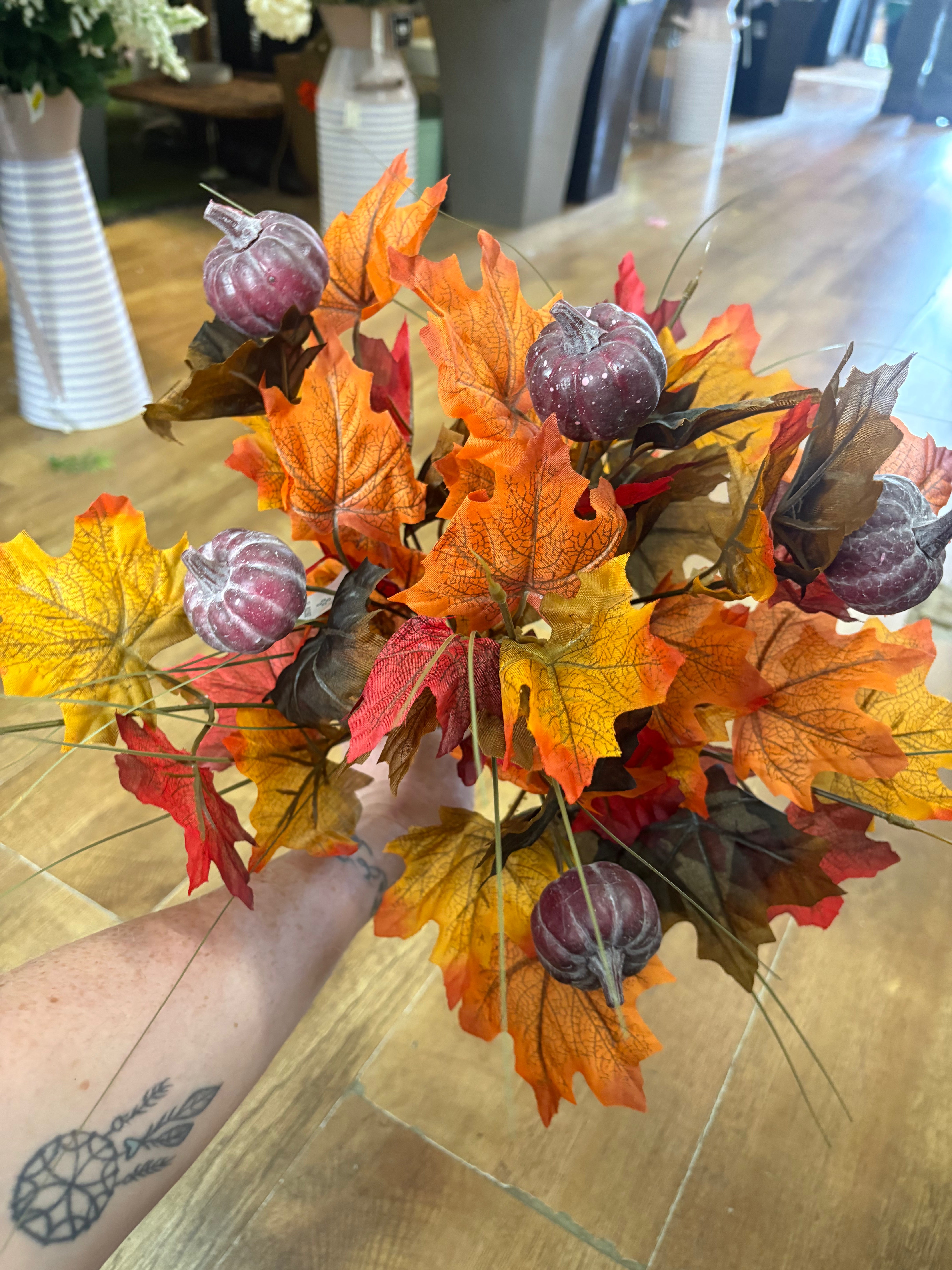 Large autumn leaves and dark pumpkins bunch