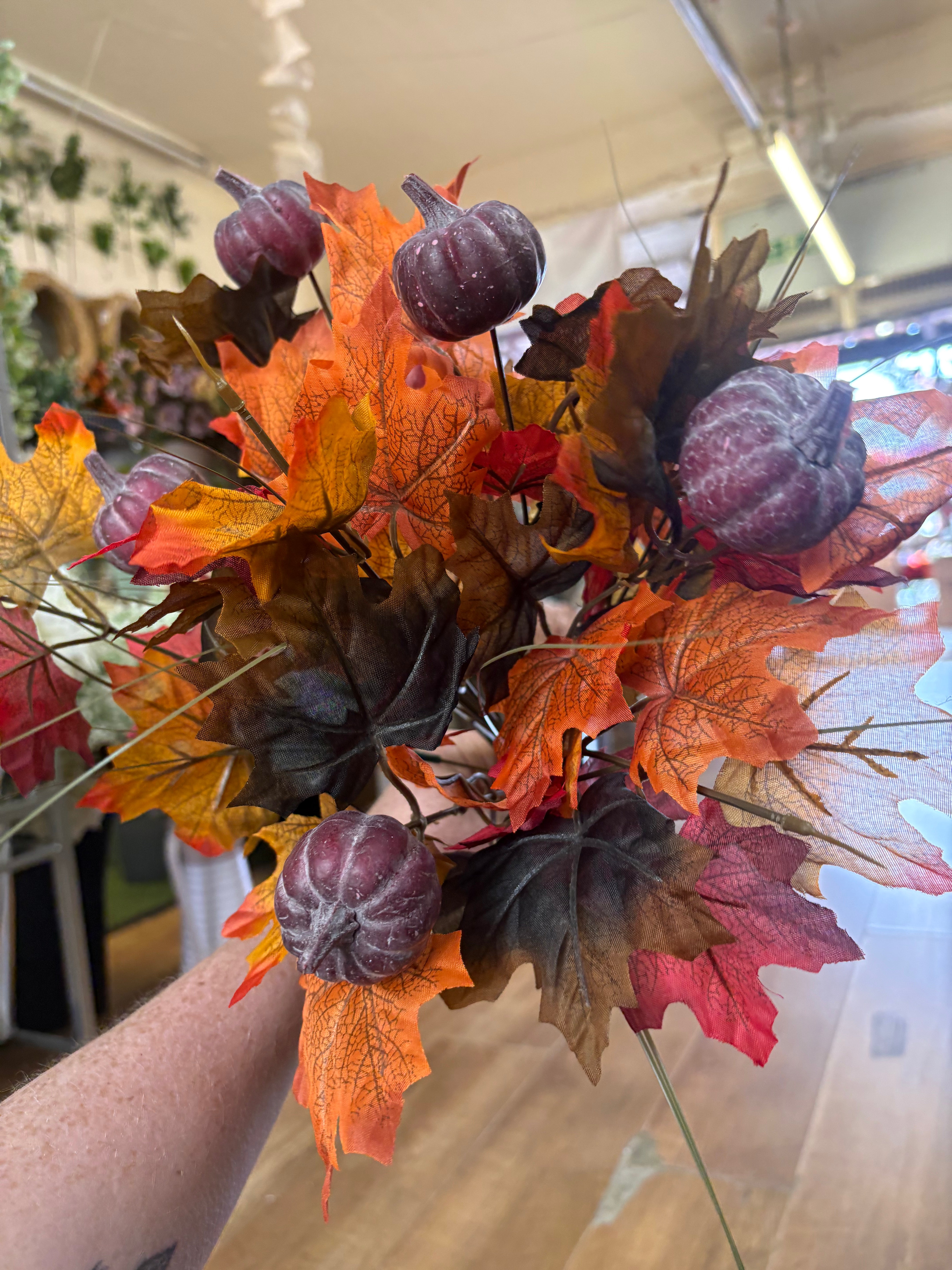 Large autumn leaves and dark pumpkins bunch