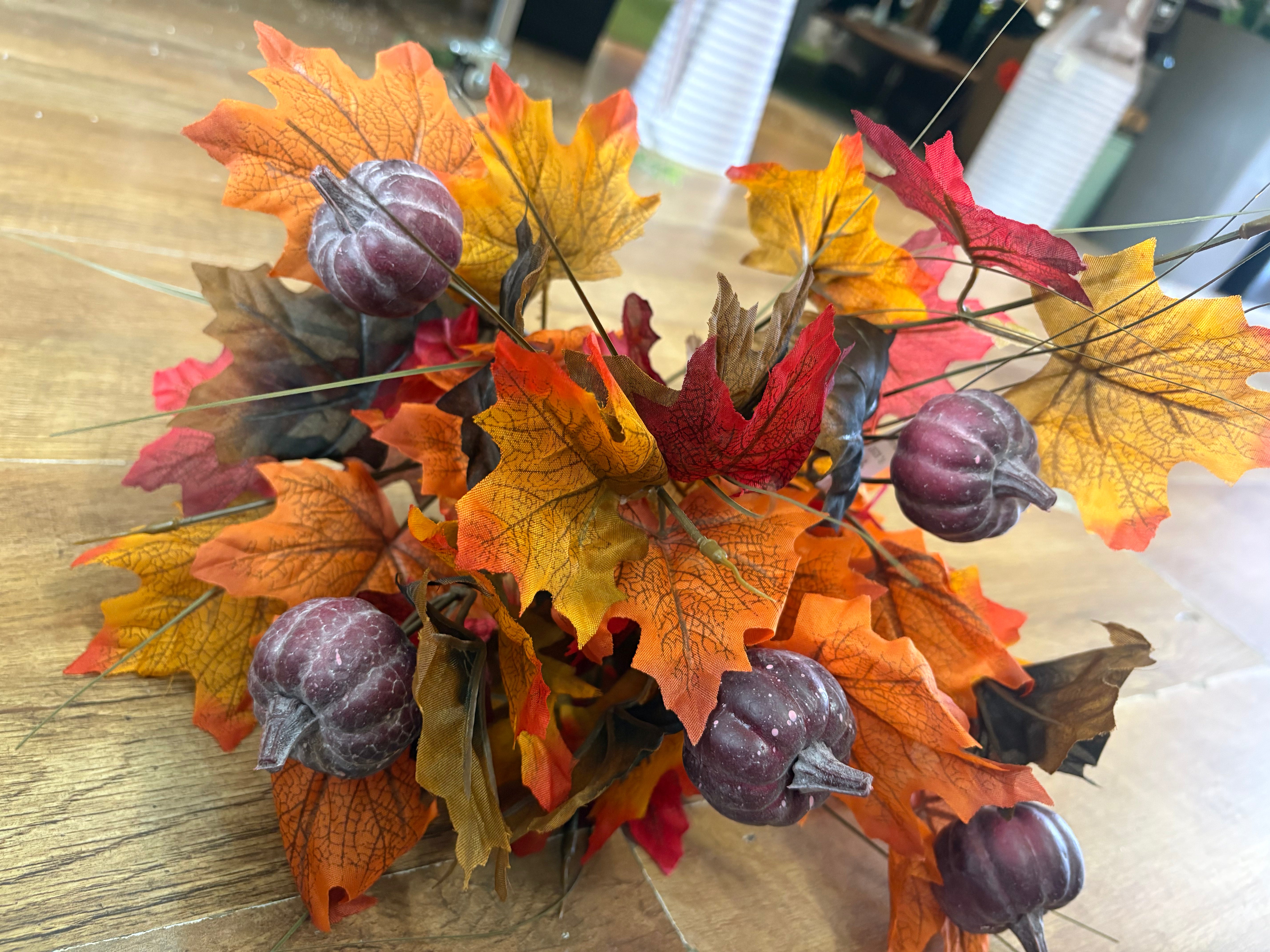 Large autumn leaves and dark pumpkins bunch