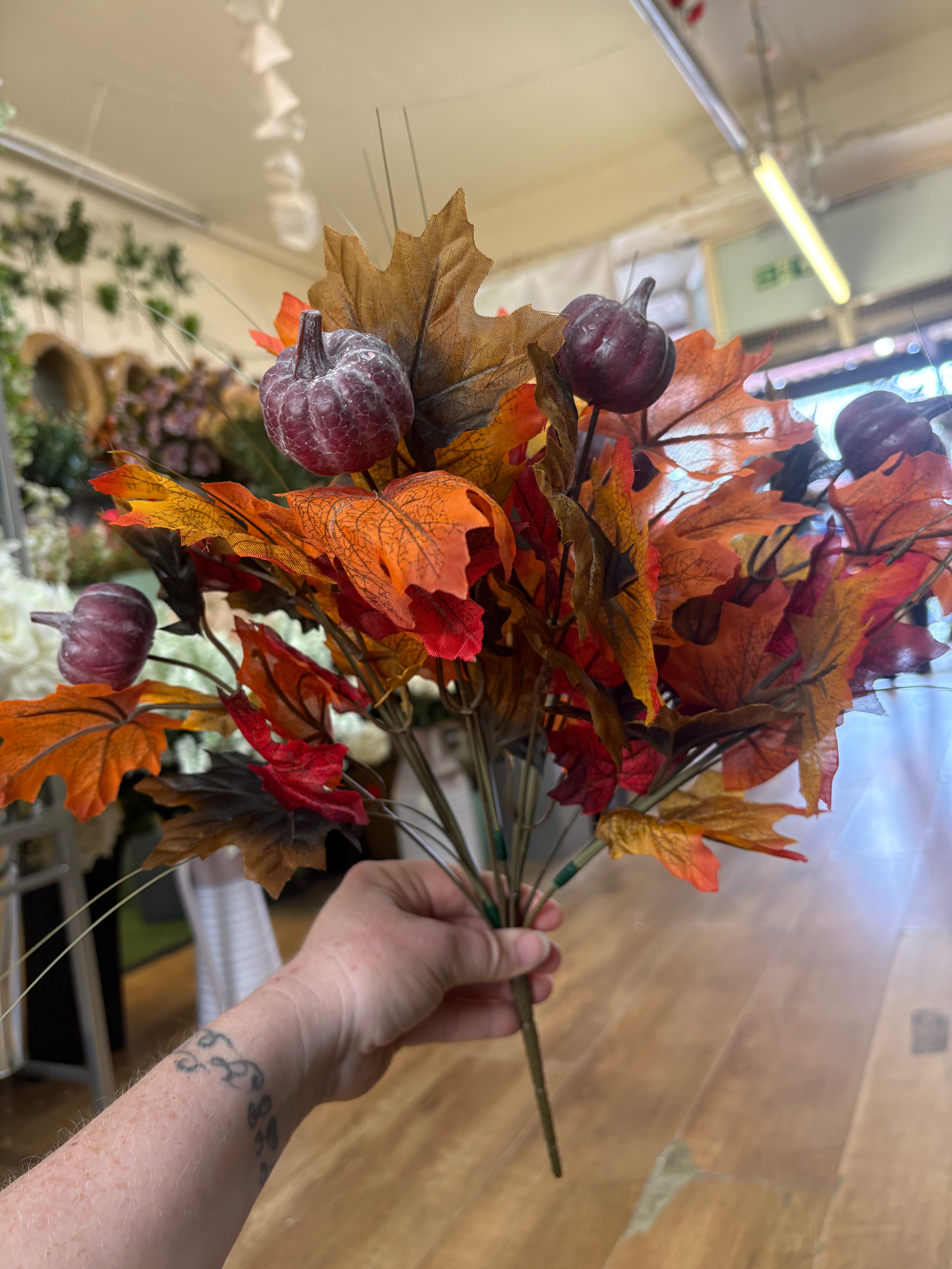 Large autumn leaves and dark pumpkins bunch