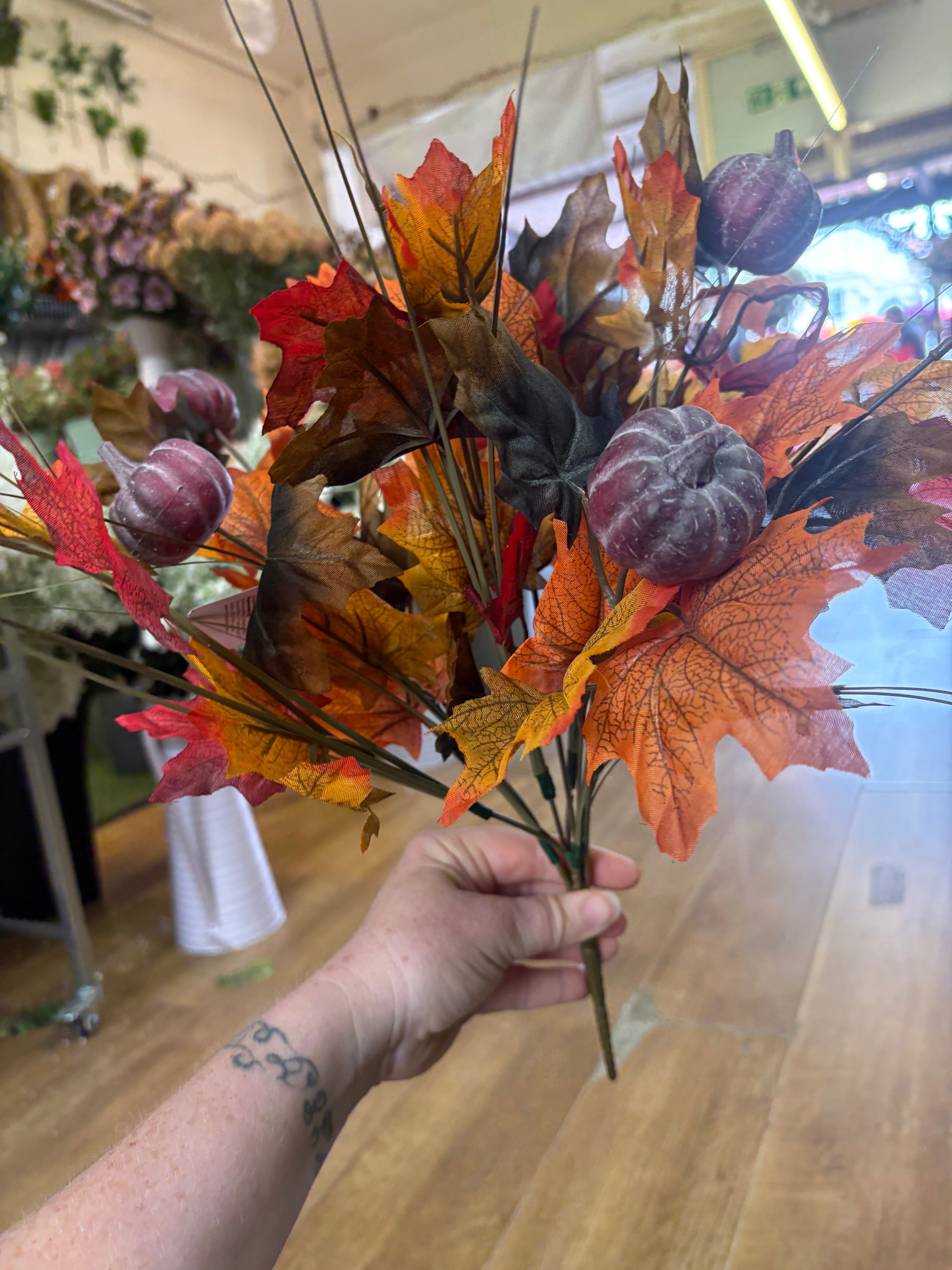Large autumn leaves and dark pumpkins bunch
